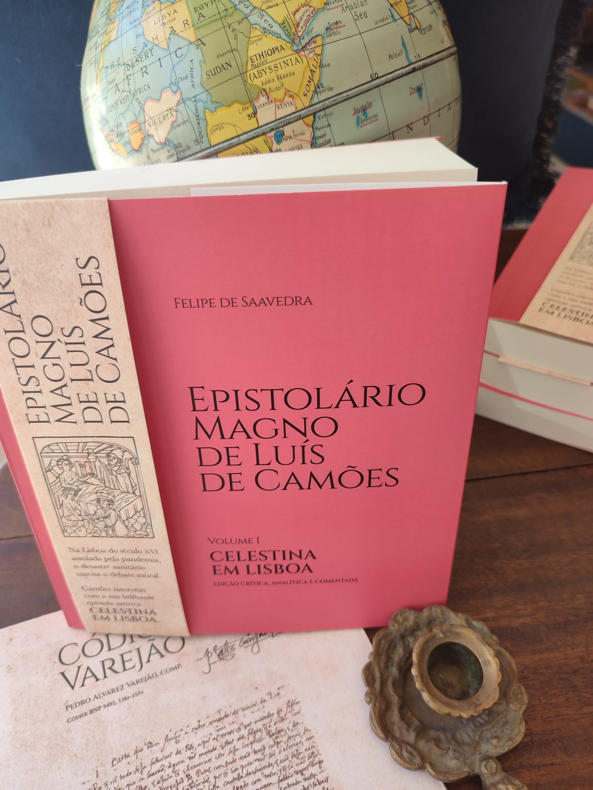 Exemplar do «Epistolário Magno de Luís de Camões, volume 1 — Celestina em Lisboa», de Felipe de Saavedra, com fac-símile da Carta VI e castiçal.